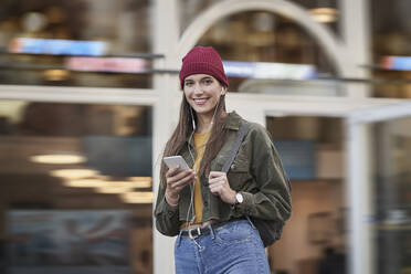 Smiling woman standing in front of building - RORF02854