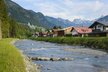 Germany, Bavaria, Oberstdorf, Trettach river flowing past mountain town in summer - WIF04436