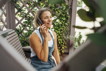 Bäuerin telefoniert in der Gärtnerei mit ihrem Handy - VPIF04647