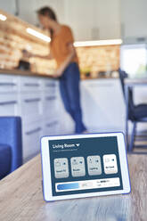 Digitales Tablet mit Smart-Home-Anwendung auf dem Tisch zu Hause - ABIF01510