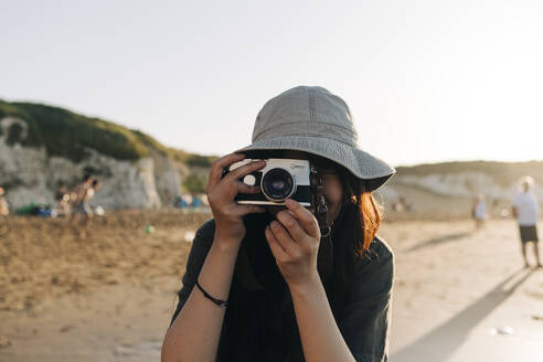 Junge Frau fotografiert durch die Kamera am Strand - ASGF01248