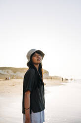 Junge Frau, die am Strand steht und träumt - ASGF01251