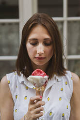 Young woman with brown hair looking at ice cream - AFVF09069