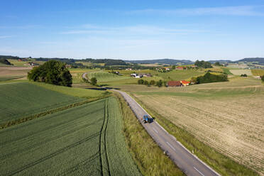 Österreich, Oberösterreich, Waldzell, Drohnenansicht einer Landstraße, die sich zwischen Feldern im Sommer erstreckt - WWF05782