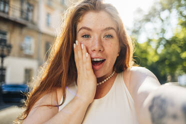 Surprised young woman with freckles taking selfie - OYF00464