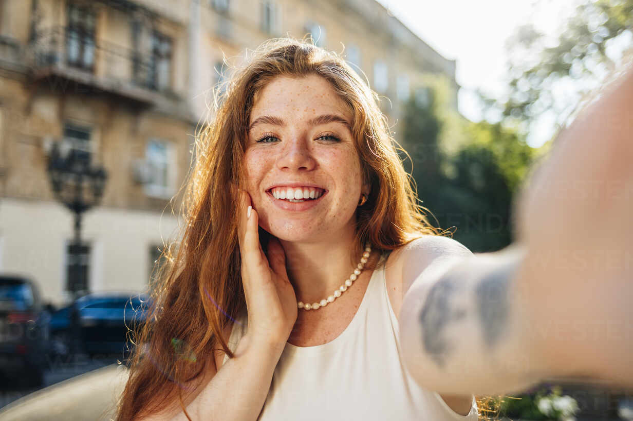 Smiling young woman talking selfie stock photo