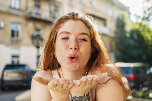 Redhead woman gesturing while blowing kiss - OYF00467