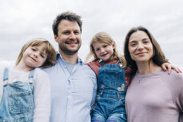 Smiling parents and daughters standing together - ASGF01359