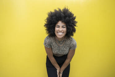 Afro-Frau lächelnd vor gelber Wand - JCCMF03706