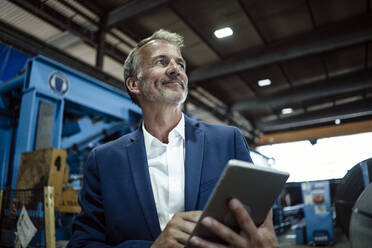 Älterer Geschäftsmann mit digitalem Tablet in der Metallindustrie - GUSF06185