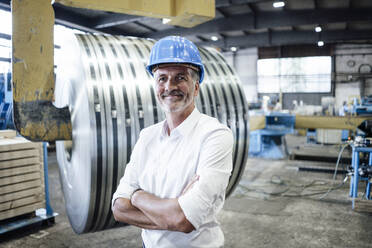 Male engineer with arms crossed standing at metal industry - GUSF06199
