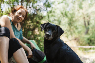 Lächelnde Frau und Hund im Wald - MRRF01404