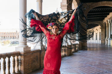 Flamenco-Künstlerin mit Schal und erhobenen Händen auf der Plaza De Espana in Sevilla, Spanien - JRVF01683