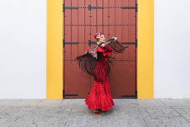 Künstlerin in Flamenco-Kleid und Schal tanzt auf einem Fußweg - JRVF01698