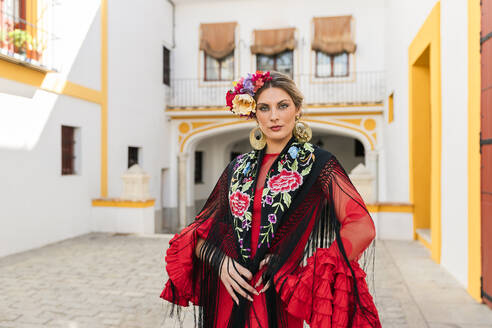 Frau in traditioneller Kleidung auf der Plaza de toros de la Real Maestranza de Caballeria de Sevilla, Spanien - JRVF01701