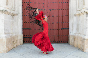 Weiblicher Flamencotanz mit erhobenen Händen an der Tür - JRVF01705