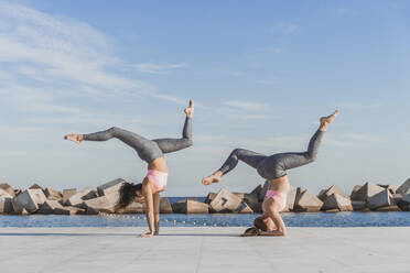 Women acrobats exercising on boardwalk - AFVF09103