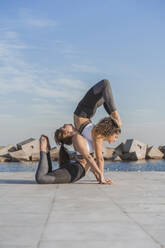 Young female friends doing acroyoga - AFVF09121