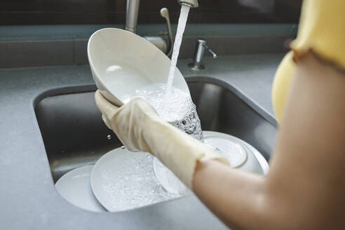 Ältere Frau wäscht Utensilien in der Spüle zu Hause - JCCMF03764