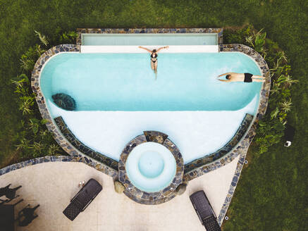 Top view couple in a swimming pool enjoying a sunny summer day - ADSF29314