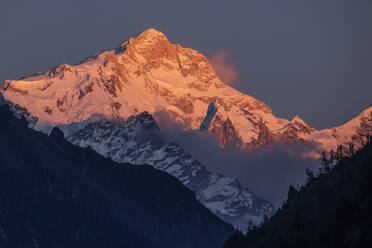 Felsige, schneebedeckte Himalaya-Berge im orangefarbenen Licht des Sonnenuntergangs in Nepal - ADSF29414