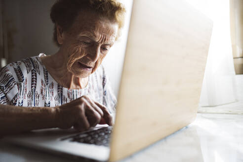 Ältere Frau im Ruhestand benutzt Laptop zu Hause - JCCMF03780
