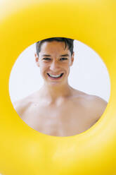 Lächelnder Teenager, der durch einen Schwimmer schaut - OCMF02215