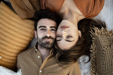 Young couple lying on picnic blanket - RCPF01239