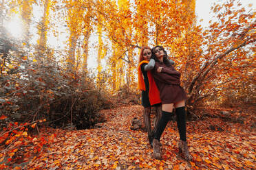 Freunde mit Halloween-Make-up und Kostüm stehen im Wald im Herbst - MRRF01465