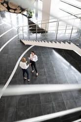 Multiracial businesswomen discussing work near stairway - CAVF94681