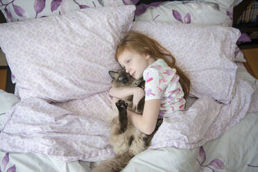 Sick Little Girl Cuddling Cat in Bed - CAVF94684