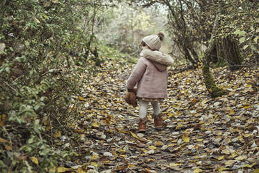 Ein 2-jähriges Mädchen in der Natur mit ihrem Teddybär - CAVF94697