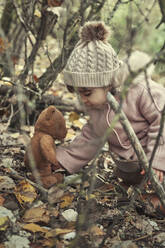 Ein 2-jähriges Mädchen in der Natur mit ihrem Teddybär - CAVF94698