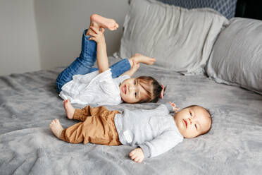 Asiatisches chinesisches Mädchen und kleiner neugeborener Baby-Bruder spielen zusammen. - CAVF94704