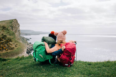Geschwister, die sich umarmen, während sie die schöne Jurassic-Küste in Dorset genießen - CAVF94718