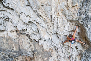 Climber on limestone wall at Crazy Horse buttress in northern Thailand - CAVF94774