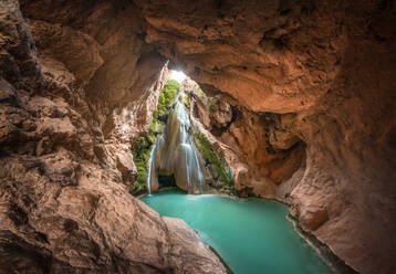 Wasserfall in einer Höhle und ein See mit kristallklarem, türkisfarbenem Wasser. - CAVF94804