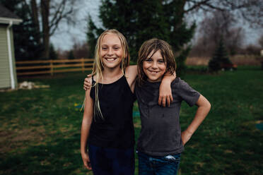 Junge und Mädchen posieren mit einem breiten Lächeln für die Kamera - CAVF94853