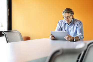 Businessman working on digital tablet in board room - PESF03172