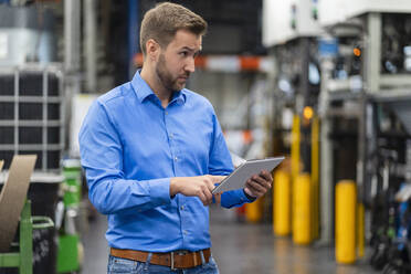 Businessman with digital tablet working in factory - DIGF16405