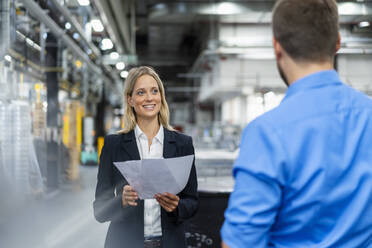 Female manager having discussion with colleague at industry - DIGF16492