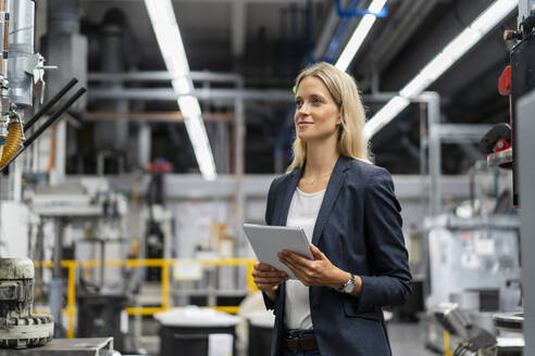 Female business professional with digital tablet in factory - DIGF16539