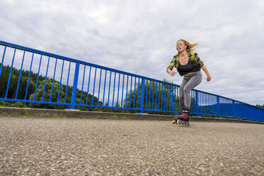 Junge Frau auf Inline-Skates über die Remsbrucker Brücke - STSF03029