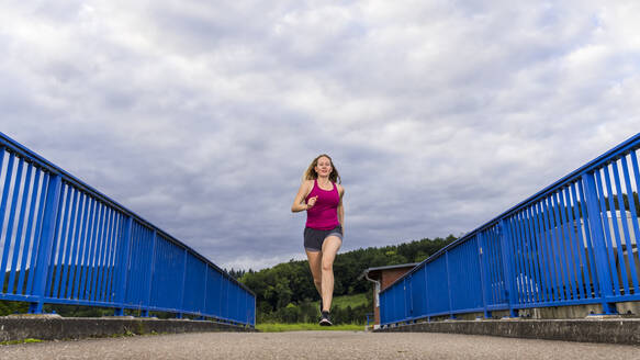 Junge Frau joggt über die Remsbrucker Brücke - STSF03034