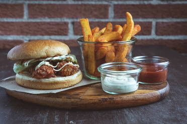 Nahaufnahme eines panierten Hühnchen-Burgers mit Pommes frites - CAVF94891