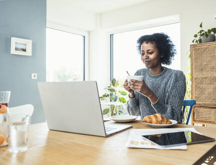 Weibliche Fachkraft beim Kaffee trinken im Home Office - UUF24614