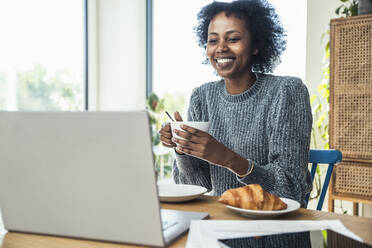 Smiling businesswoman talking during video conference at home - UUF24615