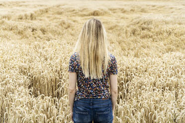 Blonde Frau steht im Weizenfeld - CHPF00783