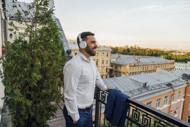 Geschäftsmann hört Musik im Büro Balkon - VPIF04759