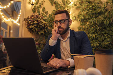 Nachdenklicher Geschäftsmann mit Blick auf Laptop im Büro Balkon - VPIF04797